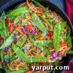 A vibrant bowl of Sesame Ginger Noodles with mixed vegetables and chickpeas.