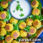 Roasted Butternut Squash Falafel Bites on a platter with dipping sauce, a perfect healthy fall appetizer that's gluten-free, vegan, and refined sugar-free.