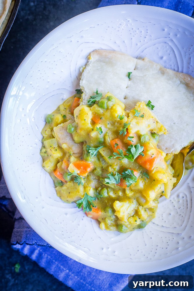 Golden Curry Veggie Pot Pie 5 A freshly baked Curried Vegetable Pot Pie, steaming hot and ready to be enjoyed, garnished with fresh parsley. The perfect vegan comfort food. #vegan #vegetarian #dinner #comfortfood #potpie
