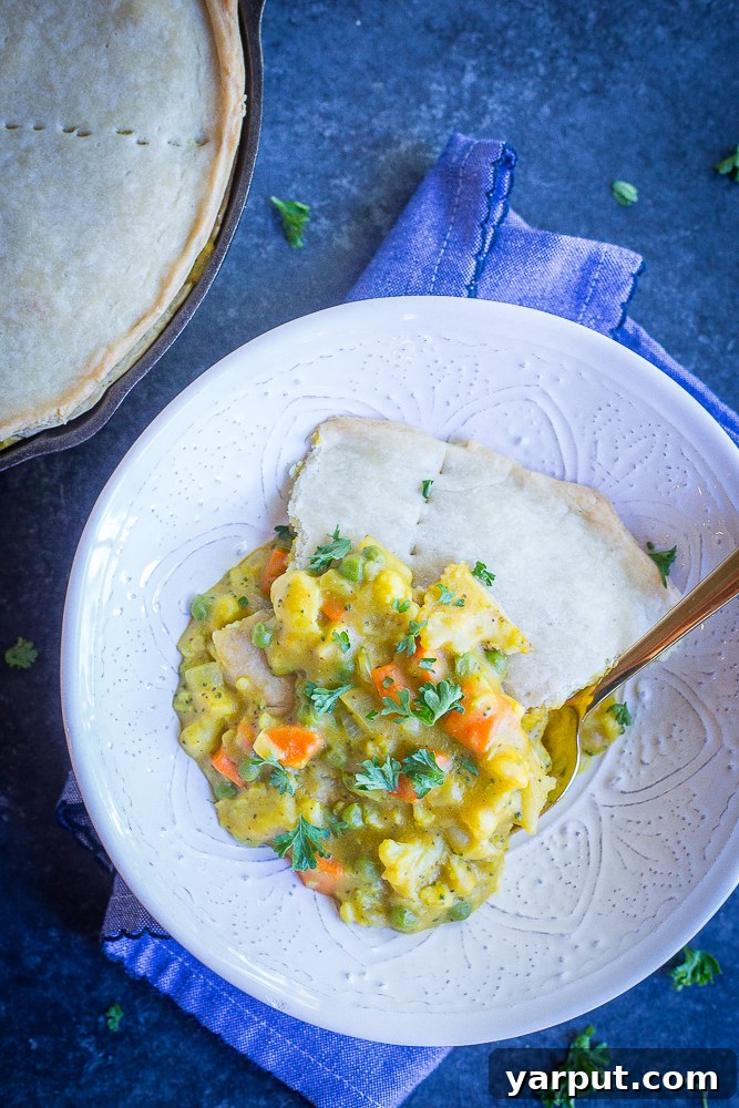 Golden Curry Veggie Pot Pie 6 A generous slice of Curried Vegetable Pot Pie on a plate, showing the creamy curry filling and the golden, crisp crust, ready to be enjoyed. #vegan #vegetarian #dinner #comfortfood #potpie