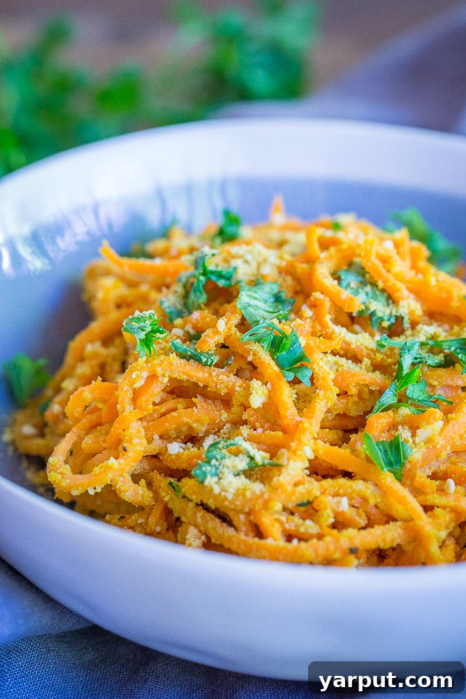 A serving of vegan Garlic Parmesan Sweet Potato Noodles, garnished with fresh parsley, highlighting its vibrant and healthy appeal.