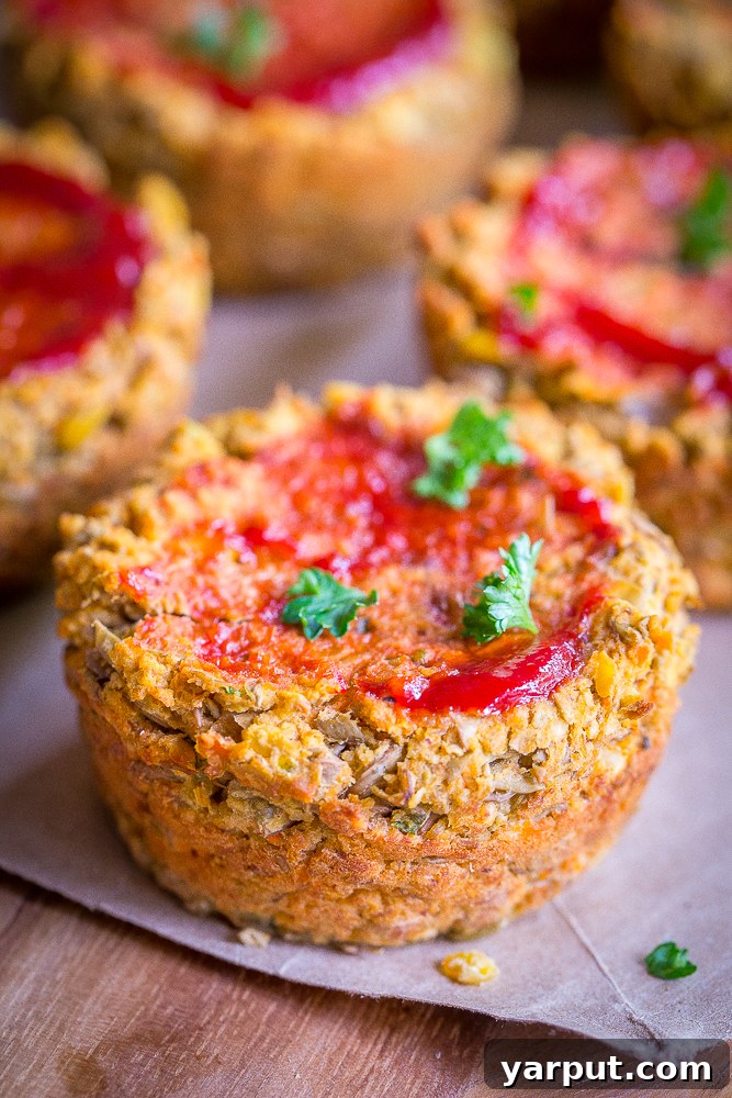 Savory Plant-Powered Lentil Loaf Muffins 3 Two golden-brown Vegan Lentil Meatloaf Cups with a vibrant ketchup topping, sitting in a muffin tin, ready to be served.