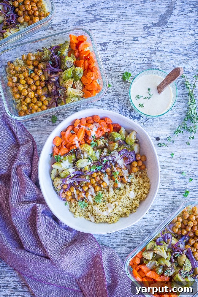 A beautifully plated Roasted Vegetable and Chickpea Meal Prep Bowl with dressing drizzled over.
