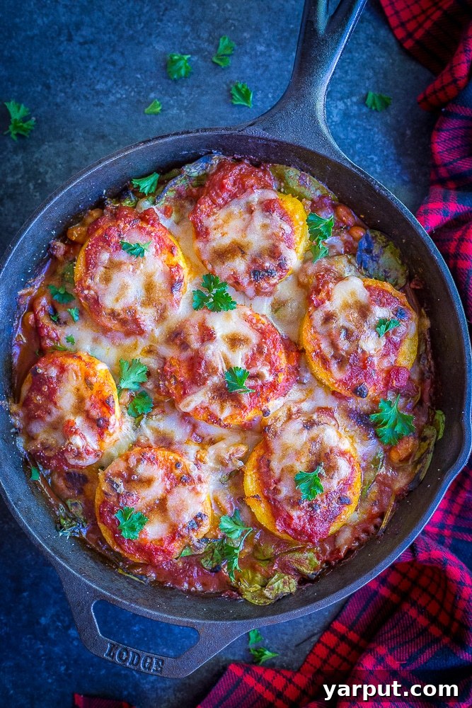 Creamy Parmesan Polenta with Garlicky Spinach and Cannellini 2 A vibrant Polenta Parmesan with crispy golden polenta slices, rich tomato sauce, fresh spinach, and creamy white beans, topped with melted cheese, served in a rustic skillet.