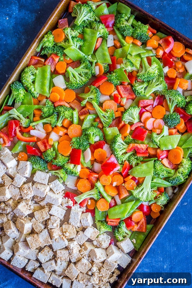 One-Pan Ginger Peanut Tofu Power Bowls 3 Tofu and various vegetables arranged on a sheet pan, ready for roasting, showcasing easy sheet pan cooking.