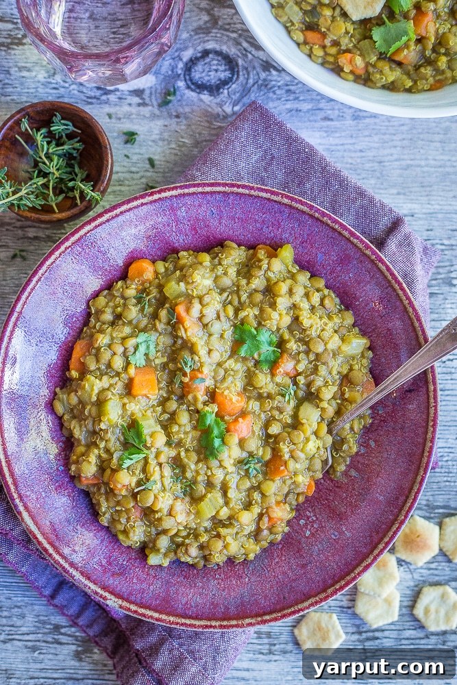 A close-up shot of the Curried Lentil Quinoa Soup simmering in a large pot, showing the rich colors and textures of the ingredients as they cook together.