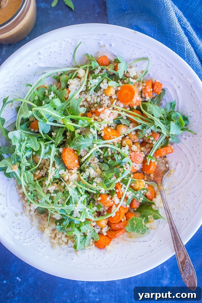 Zesty Cashew Roast Carrot Chickpea Power Bowl 3 Close-up of a roasted carrot and chickpea salad bowl, showcasing the tender roasted vegetables and the rich, creamy orange ginger cashew dressing.
