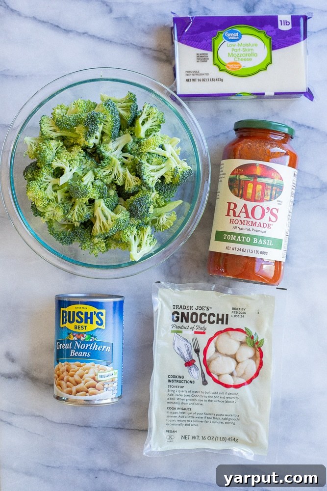 Effortless Five-Ingredient Gnocchi, Broccoli & White Bean Bake 3 Image showing the five core ingredients laid out: gnocchi package, can of white beans, fresh broccoli florets, jar of tomato sauce, and shredded mozzarella cheese.