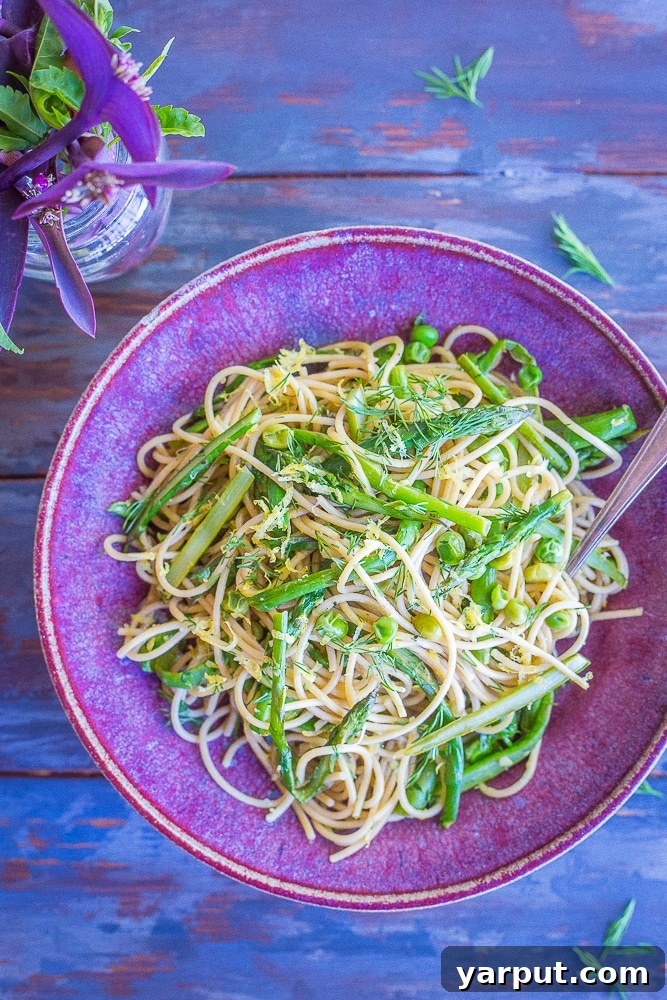 Bright Spring Pasta with Zesty Lemon and Fresh Dill 3 Close-up shot of cooked whole wheat spaghetti tossed with bright green asparagus and peas, infused with lemon and dill.