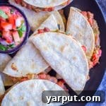 Close-up of crispy baked tacos with summer vegetables, showing golden-brown tortillas and flavorful filling.
