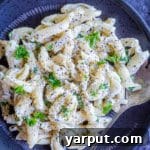 A top-down view of a serving of 30 Minute Creamy Goat Cheese Pasta with Everything Bagel Spice in a white bowl.