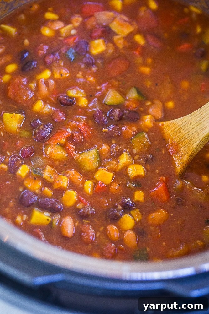 Summer Garden Instant Pot Vegetarian Chili 3 Instant Pot Vegetarian Chili simmering in the Instant Pot with a wooden spoon