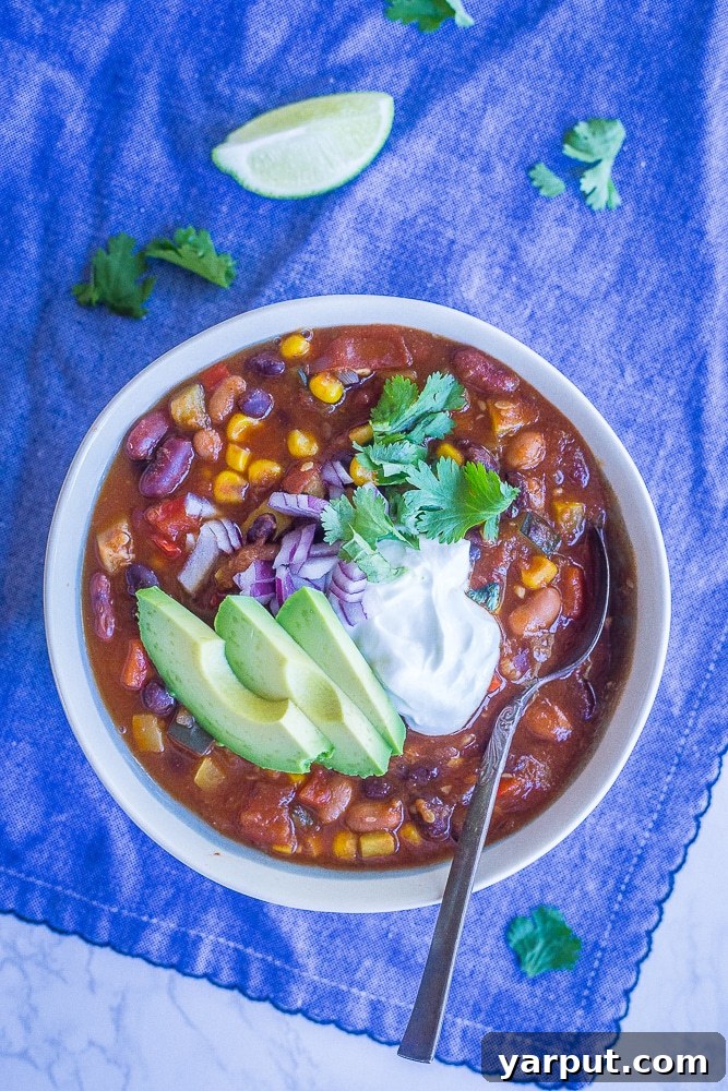 Summer Garden Instant Pot Vegetarian Chili 4 A bowl of Instant Pot Vegetarian Chili on a blue napkin with avocado and cilantro toppings
