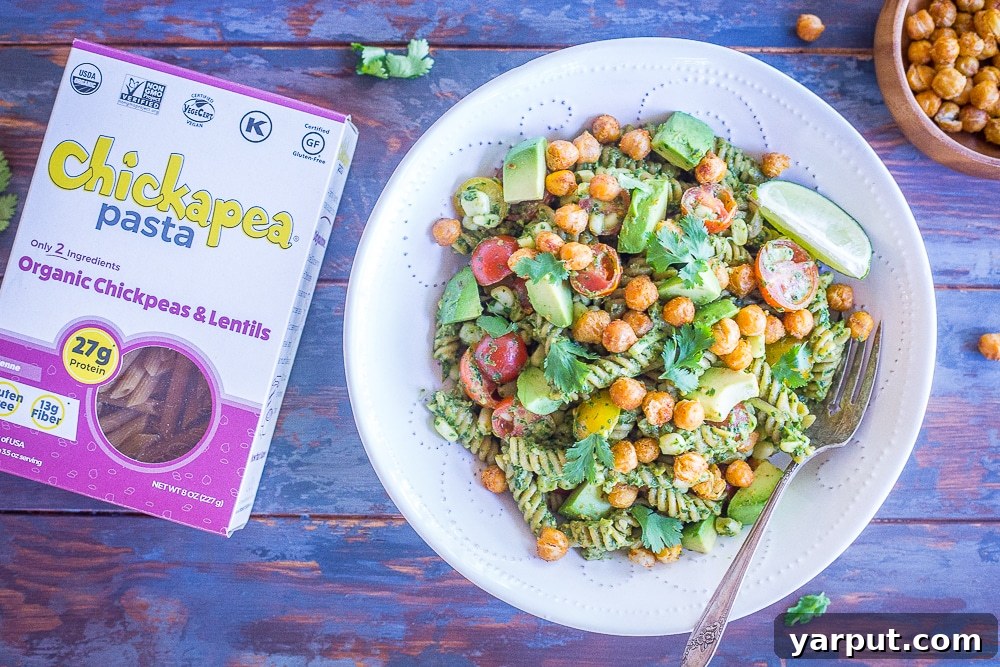 Tex-Mex Pesto Pasta with Crispy Chickpeas 3 A close-up shot of a bowl of Southwestern Pesto Pasta with Crispy Chickpeas, positioned next to a box of Chickapea Pasta, highlighting the main ingredients.