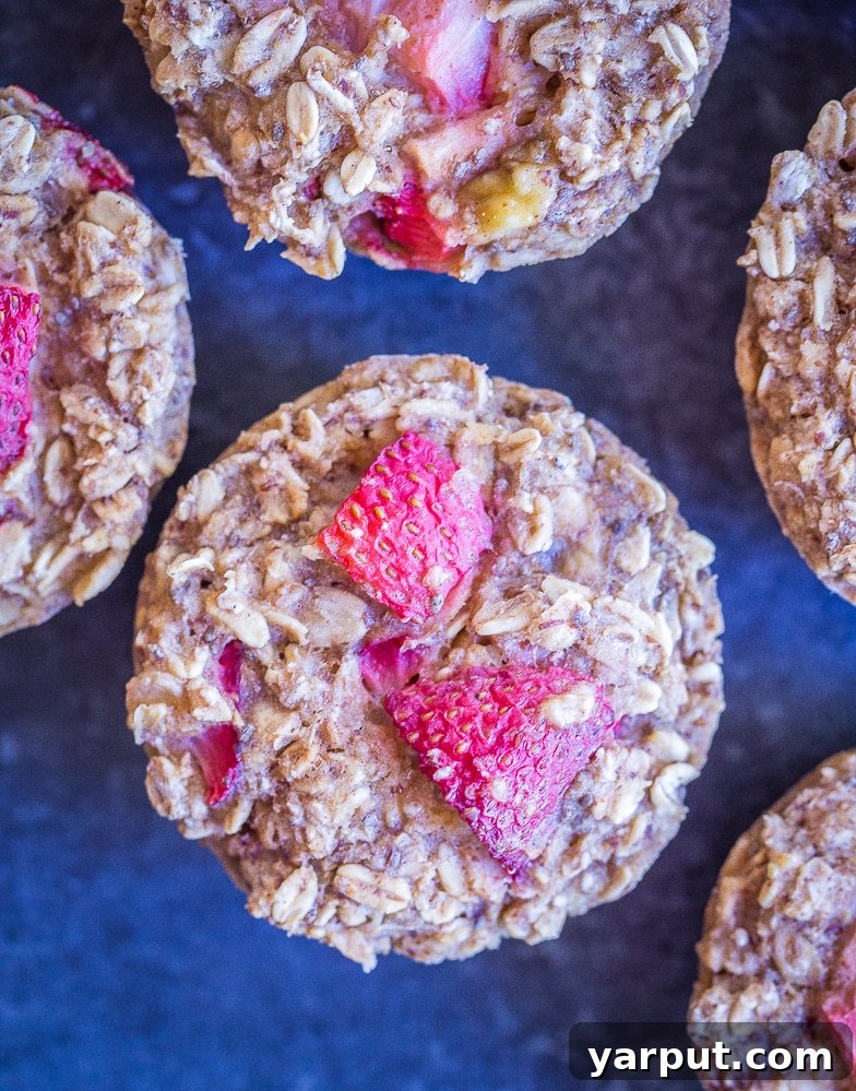 Wholesome Strawberry Banana Baked Oatmeal Cups 4 Close-up of freshly baked strawberry banana oatmeal cups, showing off their golden-brown tops and fruit inclusions.