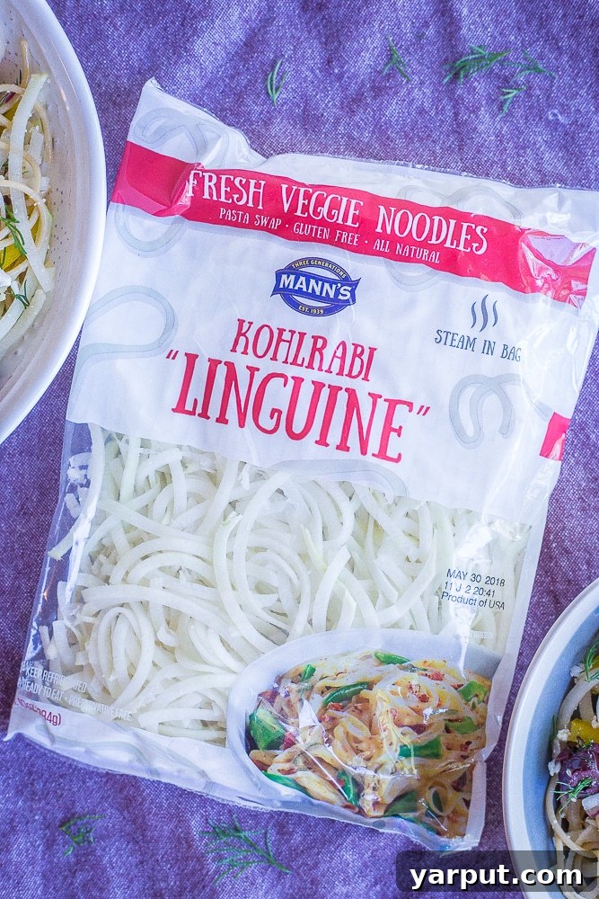 Mediterranean Kohlrabi Noodle Salad 3 A transparent bag of Mann's Kohlrabi Linguine noodles is showcased on a purple napkin, highlighting the fresh, ready-to-use vegetable pasta.