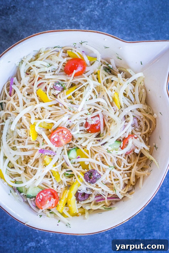 Mediterranean Kohlrabi Noodle Salad 4 A large serving bowl overflowing with Healthy Greek Pasta Salad, showcasing the abundant kohlrabi noodles, colorful vegetables, and rich dressing.