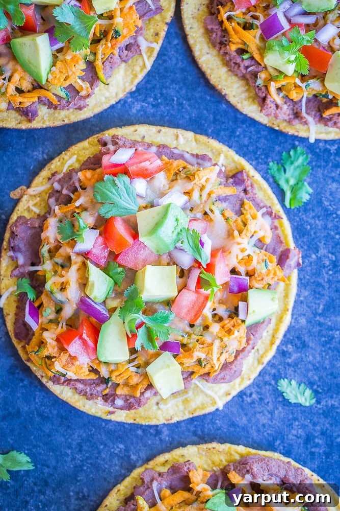 Quick and Colorful Sweet Potato Zucchini Tostadas 4 Facedown view of four 30 Minute Sweet Potato and Zucchini Tostadas on a black background, artfully arranged