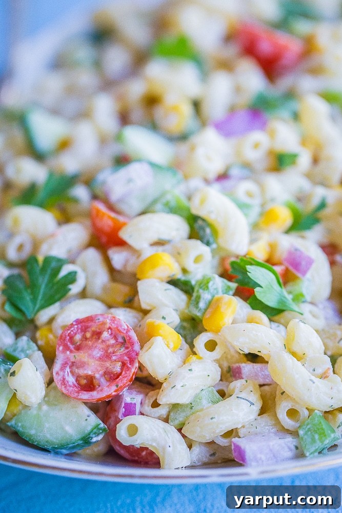 Bright & Light Macaroni Salad Without Mayo 5 An overhead view of the completed Healthier Mayo-Free Macaroni Salad on a white platter, ready to be served.