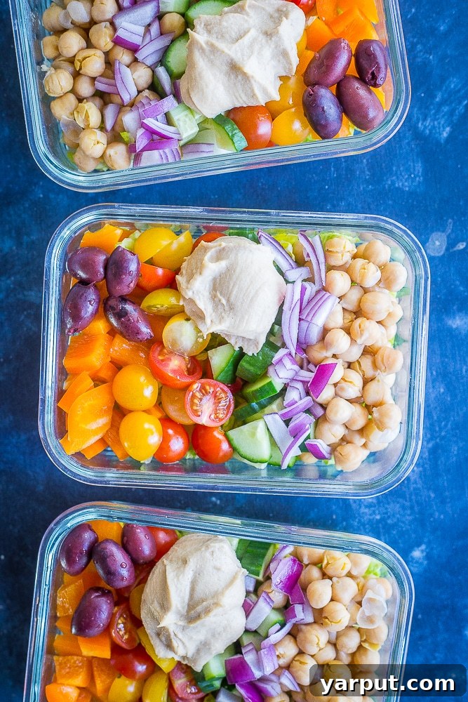 Grab-and-Go Greek Salad Prep Bowls 4 Three colorful Easy Greek Salad Meal Prep Bowls with a mix of fresh vegetables, chickpeas, and pita croutons.