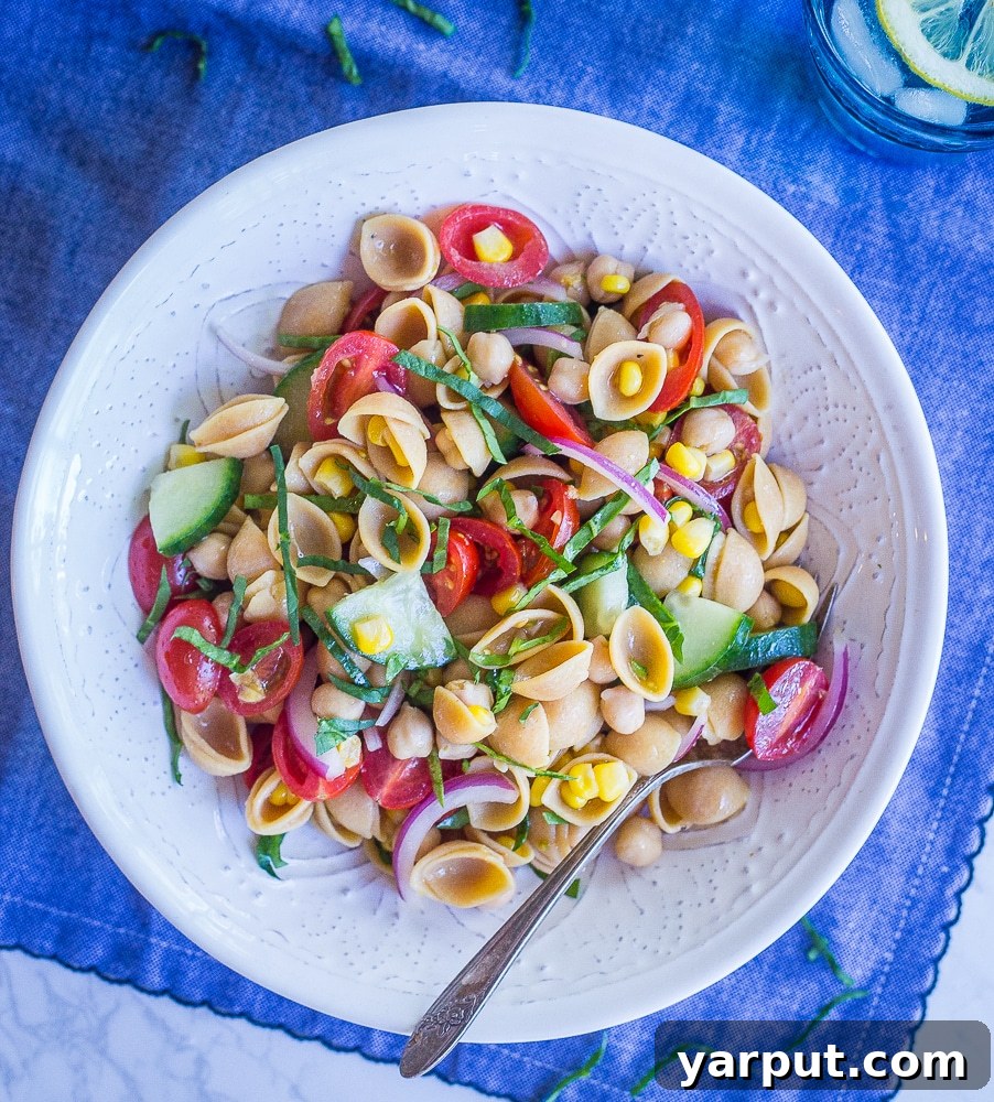 Vibrant Summer Chickpea Pasta Salad 3 A closer view of the colorful Summer Vegetable Pasta Salad, highlighting the variety of ingredients and the fresh basil leaves.