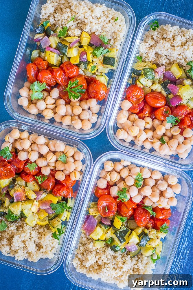 Roasted Summer Harvest Meal Prep Bowls 5 Four wholesome Roasted Summer Vegetable Meal Prep Bowls neatly stacked on a blue background, showcasing roasted vegetables, quinoa, and chickpeas, highlighting their appeal as convenient, healthy lunches.