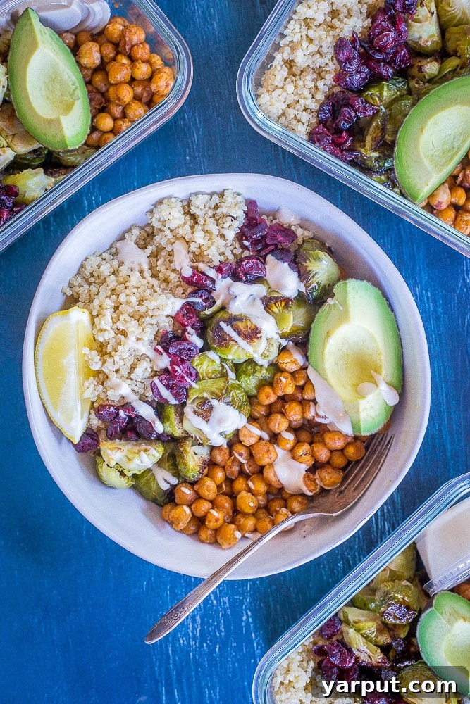 Golden Roasted Brussels & Chickpea Bowls 6 A prepared bowl of Roasted Brussels Sprout and Chickpea Meal Prep Bowls, surrounded by three additional containers, symbolizing a week of healthy, convenient lunches.