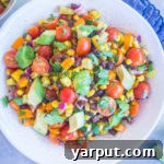 A high-angle shot of the vibrant Loaded Summer Vegetable Salad with Black Beans, indicating a delightful dish.