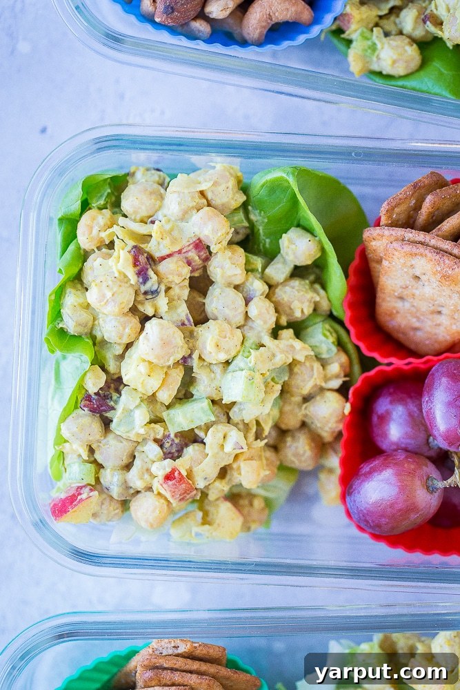 Vibrant Curried Chickpea Lunch Boxes 5 A close-up view of an open meal prep container with Curried Chickpea Salad, showing the individual compartments for different components
