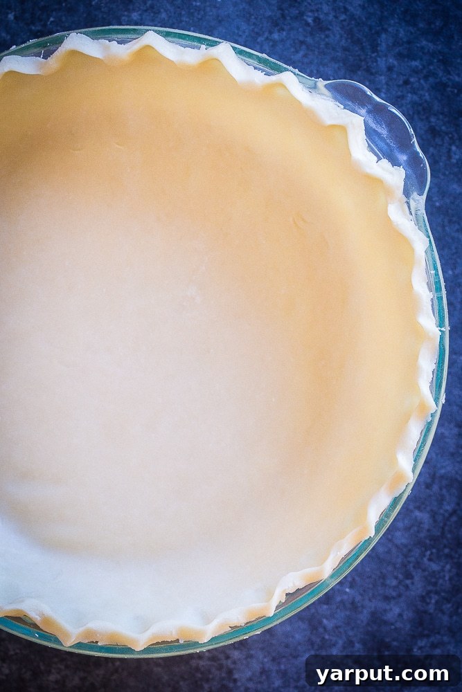 Freshly rolled out Perfect Coconut Oil Pie Crust in a pie pan, ready for filling