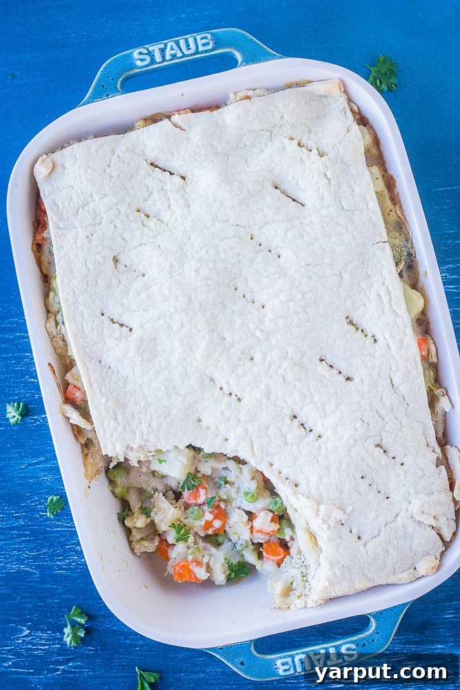 Overhead shot of Creamy Vegan Pot Pie with a spoonful taken out, revealing the creamy filling and vegetables