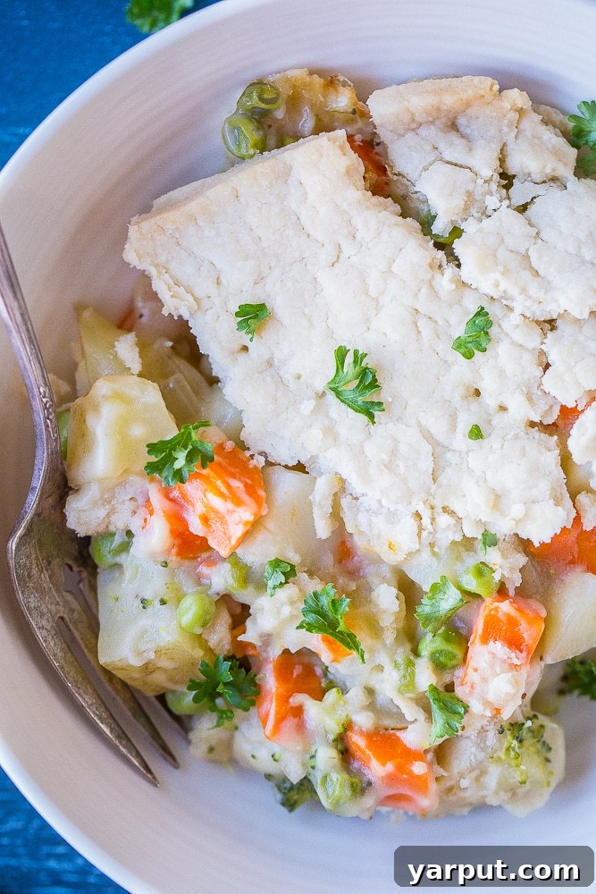Close up of Creamy Vegan Pot Pie, showing a golden, flaky crust and a hint of the creamy filling