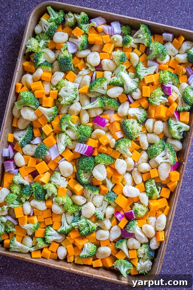 Golden Gnocchi & Harvest Veggie Sheet Pan 4 Sheet Pan Roasted Gnocchi, Butternut Squash and Broccoli before cooking, showing the fresh ingredients tossed together on a sheet pan, ready for the oven.