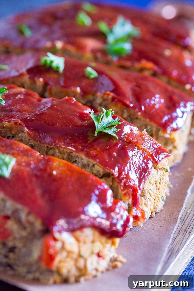 Hearty Lentil and Chickpea Vegan Meatloaf 4 Side view of Easy Vegan Meatloaf with Lentils and Chickpeas cut into slices, showcasing the savory glaze