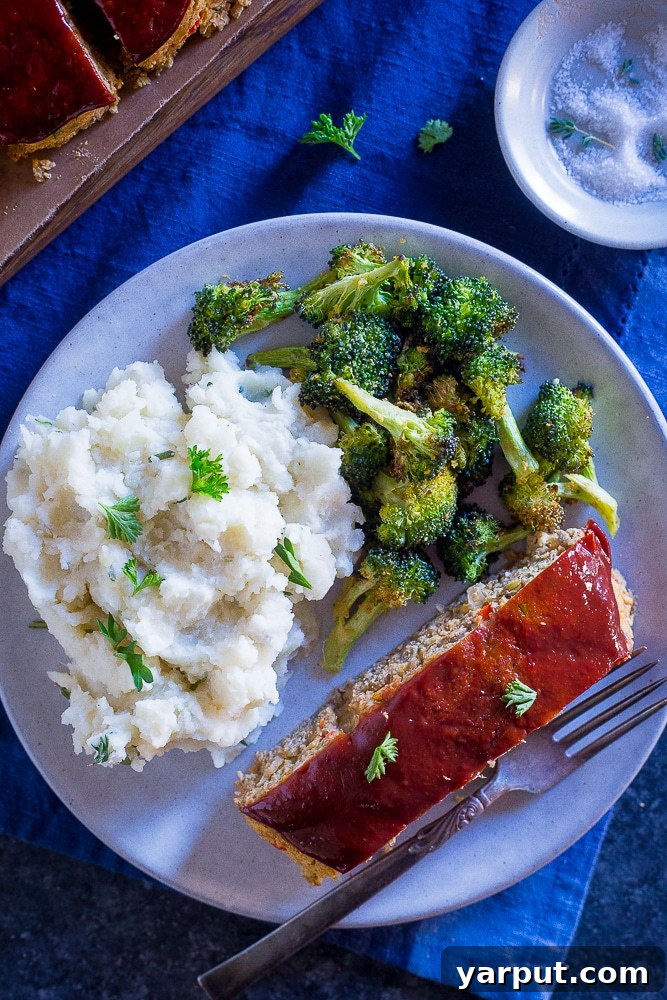 Hearty Lentil and Chickpea Vegan Meatloaf 7 Sliced vegan meatloaf on a cutting board, with fresh herbs and a rustic background, highlighting healthy eating