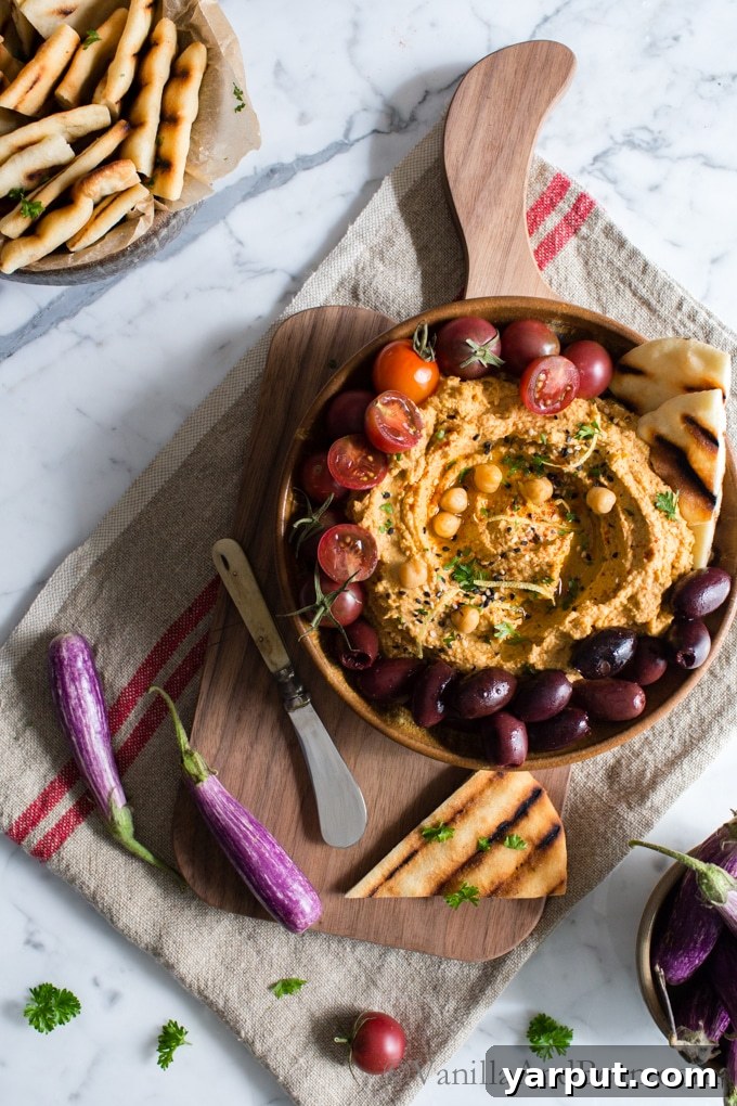 67 Vegan Holiday Recipes: Appetizers, Side Dishes, Salads, Main Courses, and Desserts 13 Smoky Roasted Eggplant Dip in a bowl with pita bread