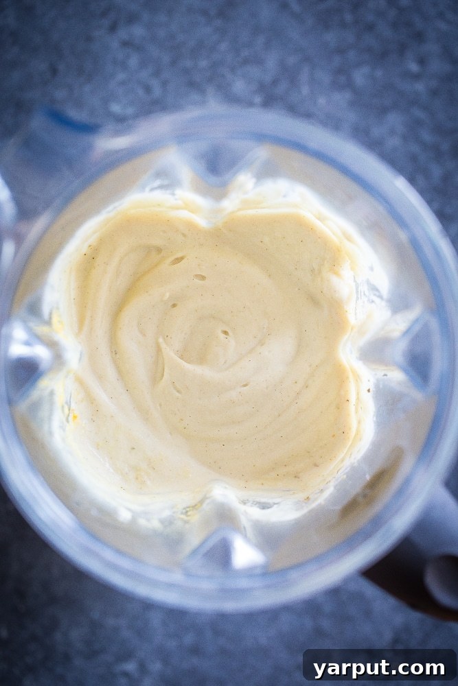 Velvety Cauliflower Alfredo 4 Creamy Cauliflower Alfredo Sauce blending smoothly in a high-powered blender, showcasing its rich, velvety texture.