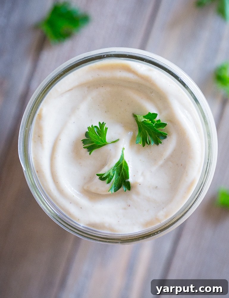 Velvety Cauliflower Alfredo 5 A flatlay shot of Creamy Cauliflower Alfredo Sauce in a charming mason jar, highlighting its rich and inviting texture.
