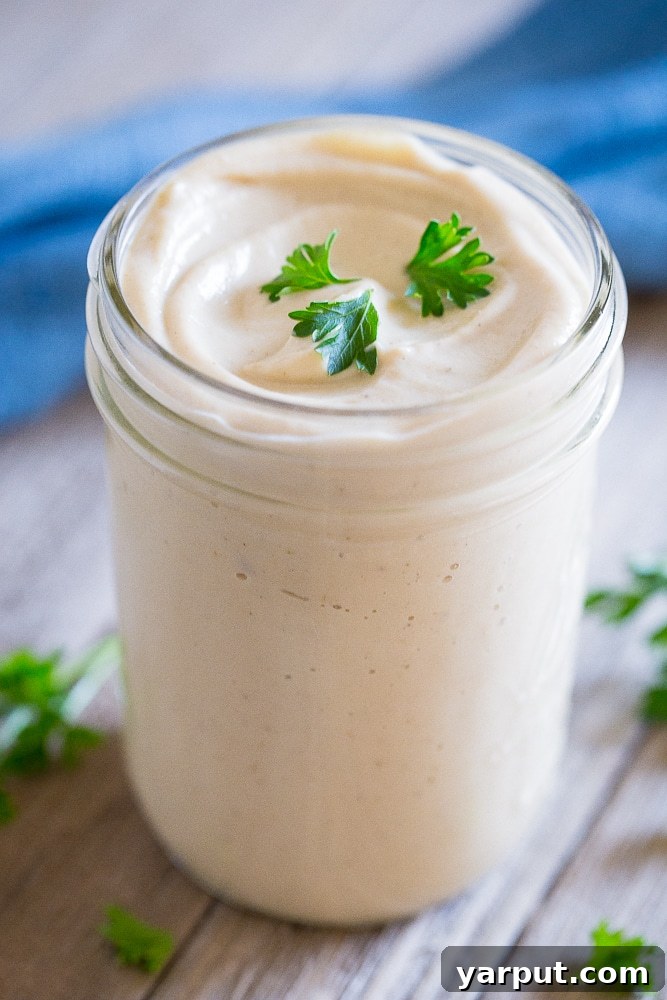 Velvety Cauliflower Alfredo 6 A glass jar filled with Creamy Cauliflower Alfredo Sauce, ready for serving or storage, showcasing its smooth texture.