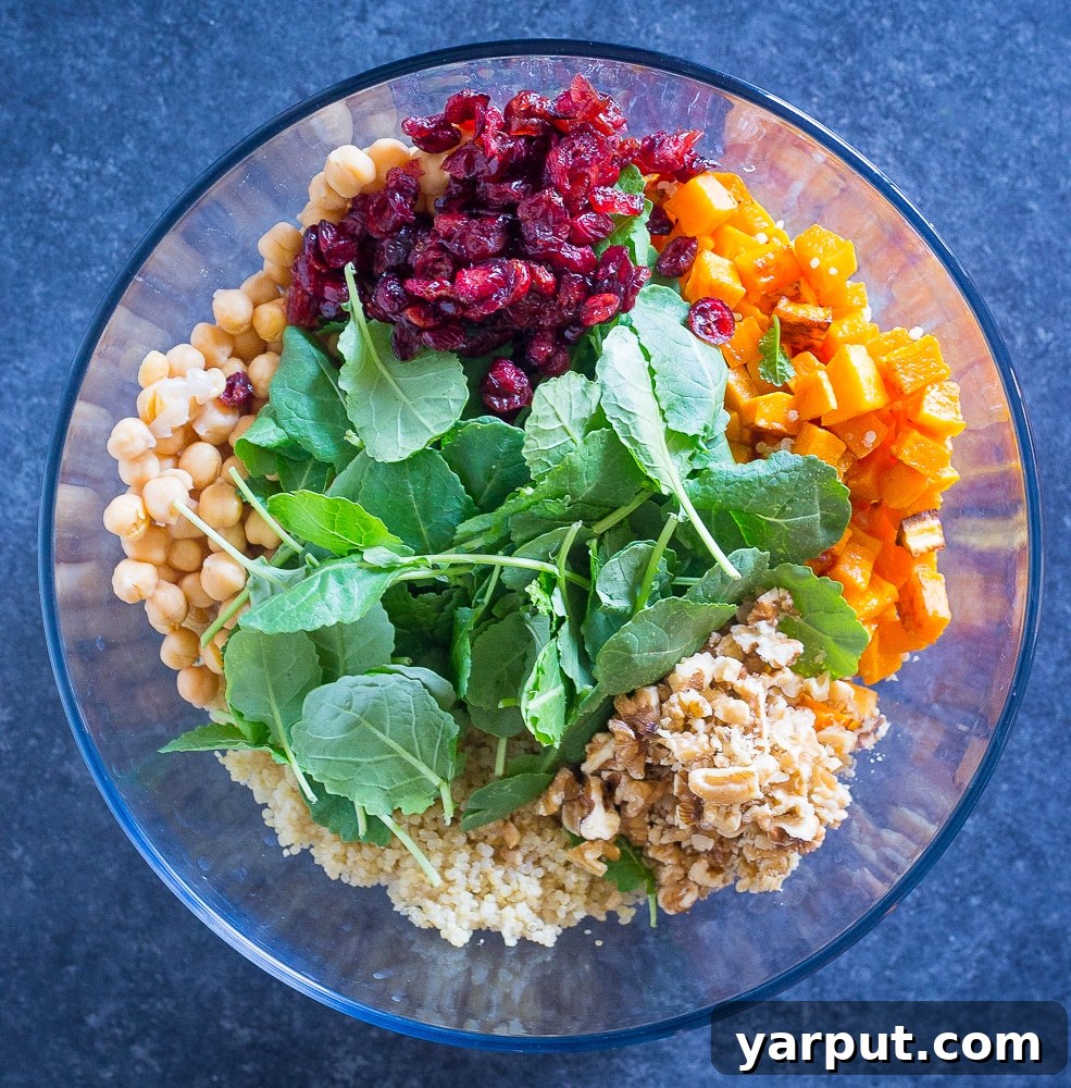Roasted Butternut & Quinoa Winter Harvest Salad 3 Bowl containing individual ingredients for Winter Quinoa Salad before mixing, showing chickpeas, kale, cranberries, and walnuts.