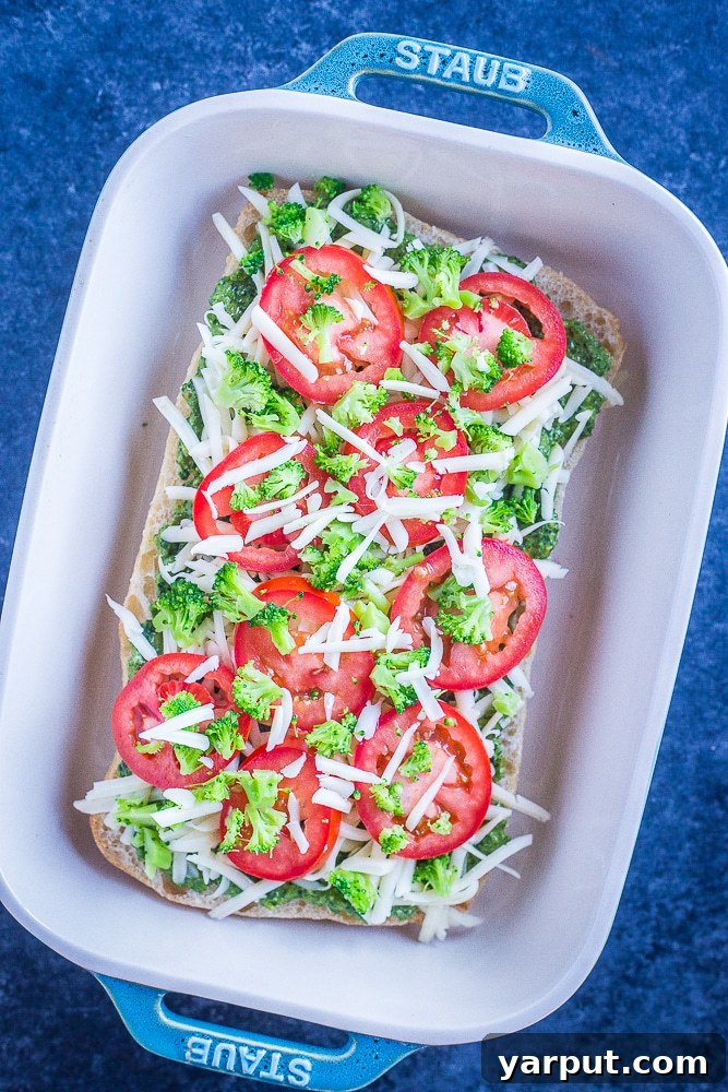 30-Minute Vegetarian Pesto French Bread Pizza Perfection 3 Unbaked 30-Minute Vegetarian French Bread Pizzas with pesto, cheese, tomatoes, and broccoli, assembled and ready for the oven.