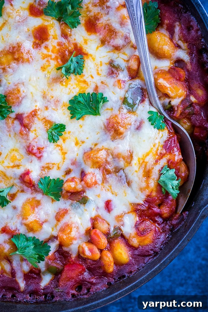 One-Pan Gnocchi Pizza Bake: 30-Minute White Bean Delight 3 Close-up of the Gnocchi Pizza Bake, showing melted cheese and colorful vegetables.