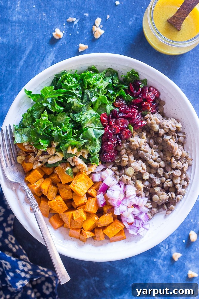 Vibrant Sweet Potato and Lentil Kale Salad 2 Hearty Kale Salad with Sweet Potato and Lentils in a serving bowl, with a small dish of Maple Mustard Dressing on the side
