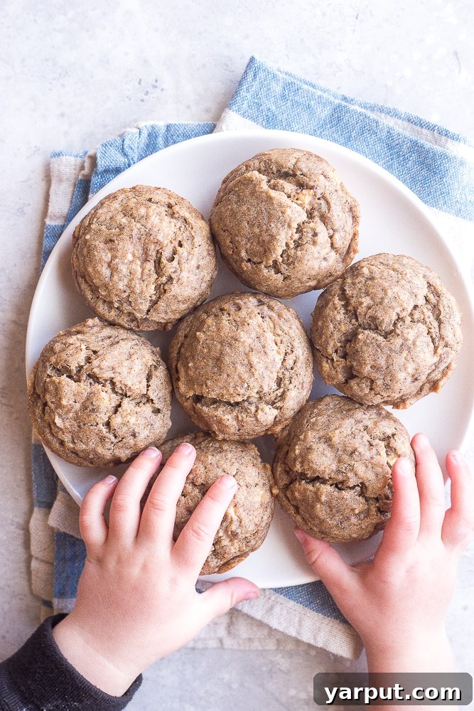 Healthy One Bowl Banana Muffins No Added Sugar 2 Toddler hands grabbing these Healthy Banana Muffins from a plate
