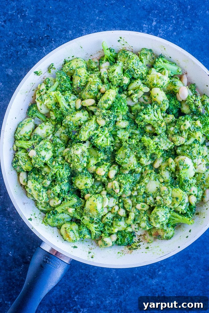 Quick 20-Minute One-Pan Pesto Gnocchi with White Beans and Broccoli 4 Pesto Gnocchi with White Beans and Broccoli cooking in a single large pan, showing the rich green pesto coating the gnocchi and vibrant vegetables