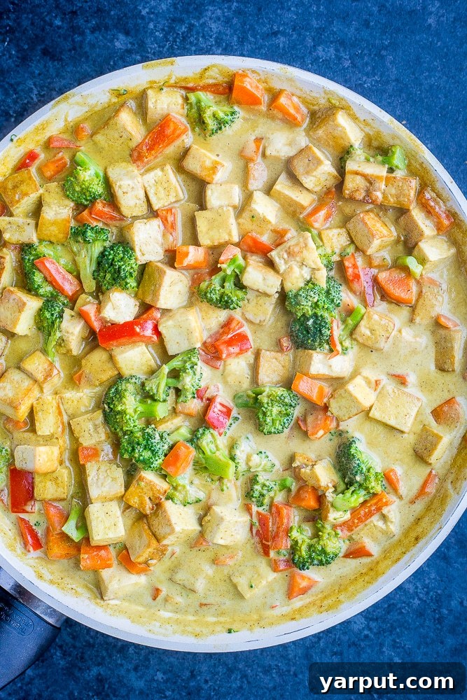 Wholesome 30-Minute One-Pot Coconut Tofu Curry 4 Close-up view of the Easy Coconut Curry cooking in a large pan, showcasing the rich, creamy sauce and tender vegetables.