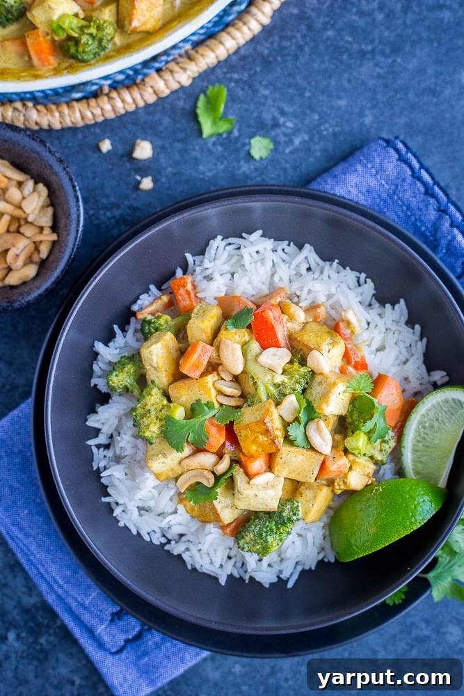 Wholesome 30-Minute One-Pot Coconut Tofu Curry 7 A beautifully plated bowl of Easy Coconut Curry with Tofu, served over rice and garnished with fresh cilantro and a lime wedge.