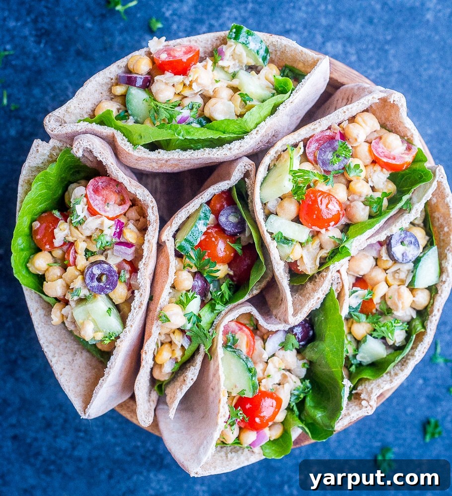 Six Greek Chickpea Salad Pitas displayed in a rustic bowl, garnished with fresh herbs, ready to be enjoyed as a healthy and quick vegan meal. These pitas are packed with protein-rich chickpeas and fresh vegetables.