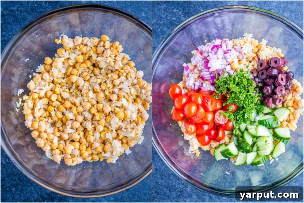 A bowl filled with the fresh ingredients for Greek Chickpea Salad Pitas, including chickpeas, olives, diced tomatoes, cucumbers, and red onions, showcasing the vibrant and healthy components of the vegan dish.