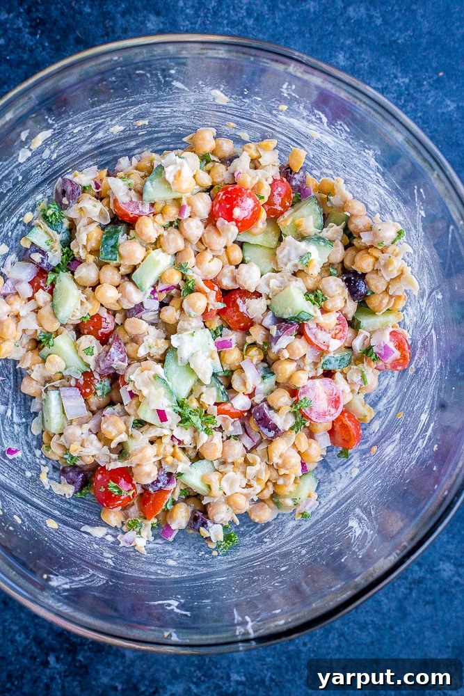 The Greek Chickpea Salad Pita ingredients mixed together in a large bowl, showcasing the vibrant colors and appealing texture of the healthy and delicious filling before being stuffed into pita bread.